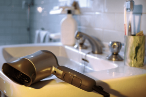 Hair dryer resting on bathroom sink ledge