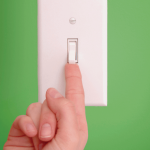Hand with finger extended to touch bottom of light switch