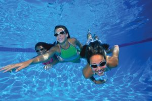 Three teenage girls swimming underwater